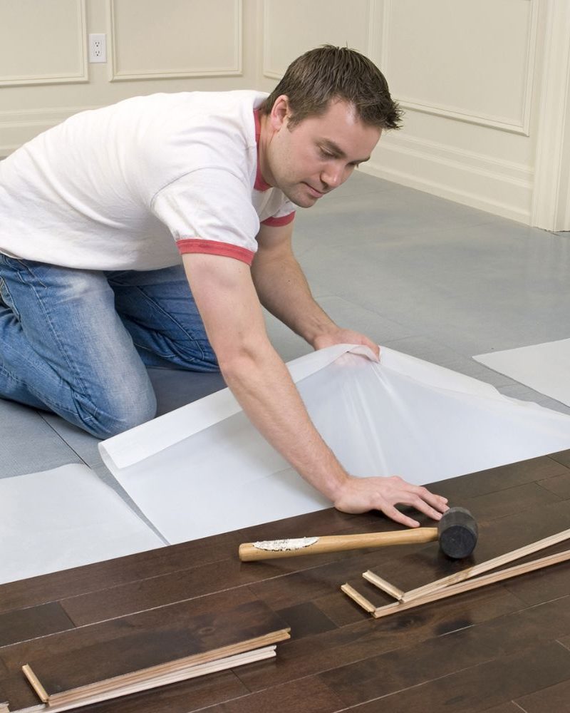 A man lays wood flooring in a room, representing a flooring service based in Honolulu, HI.