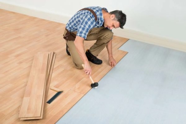 A man laying hardwood flooring, representing a flooring service based in Honolulu, HI.